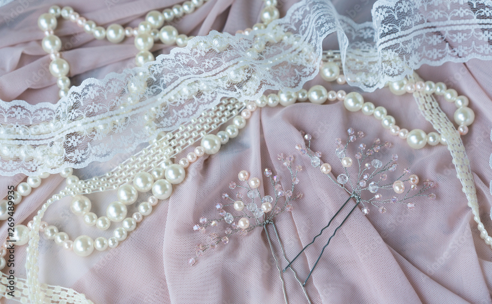 Obraz premium Wedding background with pearls and hair accessories on pink background