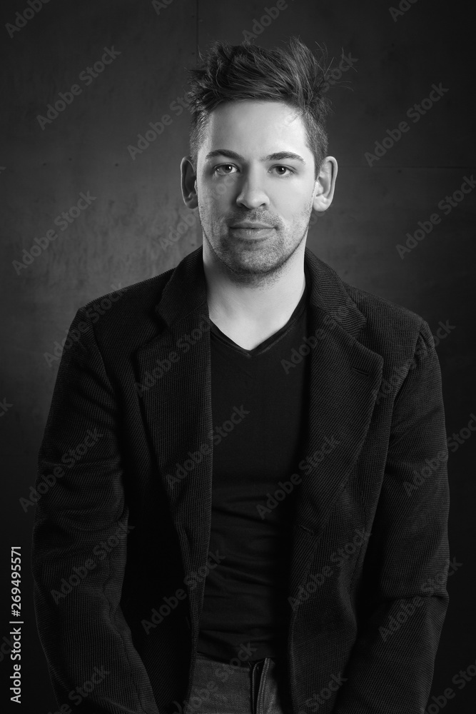 young stylish man in a blazer against a dark background young stylish man in a blazer against a dark background