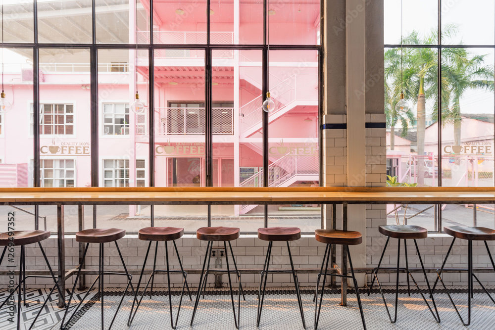 Naklejka premium A row of bar tables and chairs in front of the floor window in the dining room
