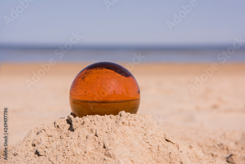 Glass sphere at the beach. Sunny summer day.