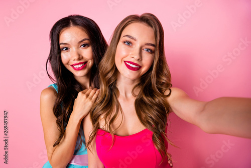 Close up photo two beautiful she her ladies graduation coquettish show perfect prom look web camera instagram followers wear shiny colorful dresses formal-wear isolated pink rose vivid background