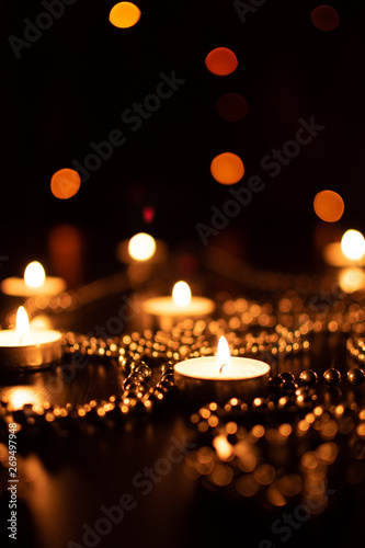 Fire of candle on christmas background. Christmas candles burning at night. Abstract candles background. Golden light of candle flame. Hope, fire. Candle lights in the darkness. © welcomeinside