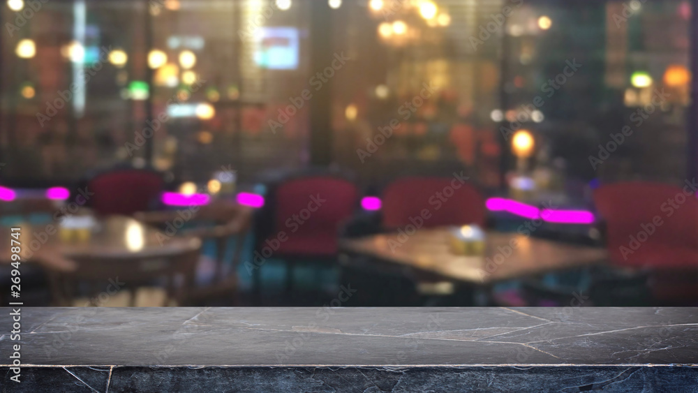 Empty black mable stone table top on abstract blurred restaurant and nightclub lights background - can be used for display or montage your products