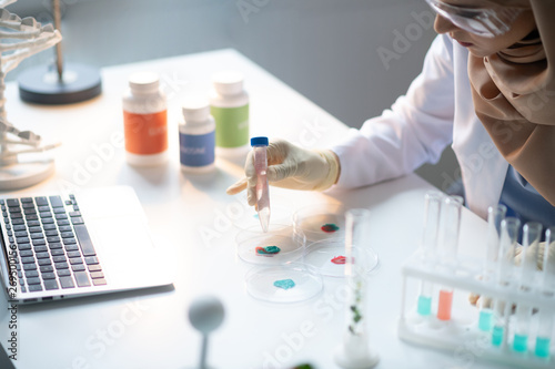 Professional chemist wearing glasses working with new chemicals
