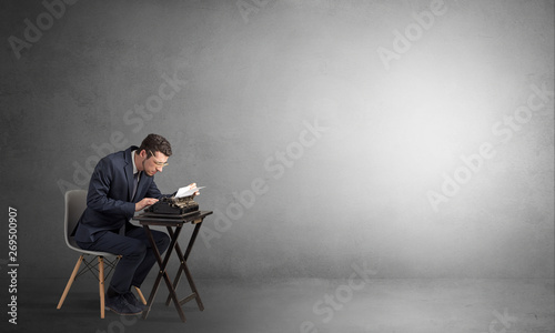 Man working hard on a typewriter in an empty space 