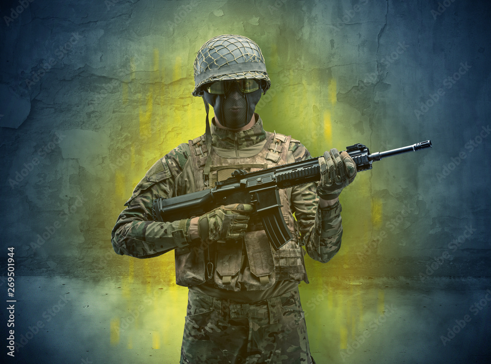 Fototapeta premium Hazard, menace soldier in a ruined crumbly building with arms on his hand 