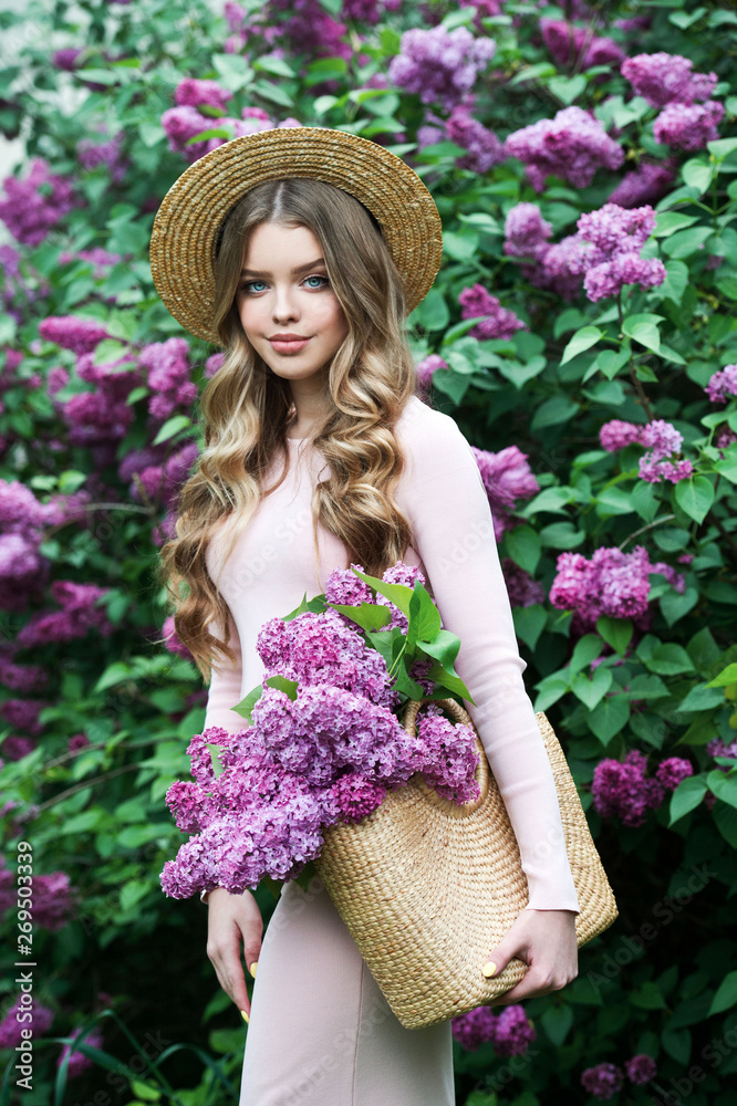 Beautiful girl in lilac Garden. Girl with lilac flowers in springtime. Gardening.