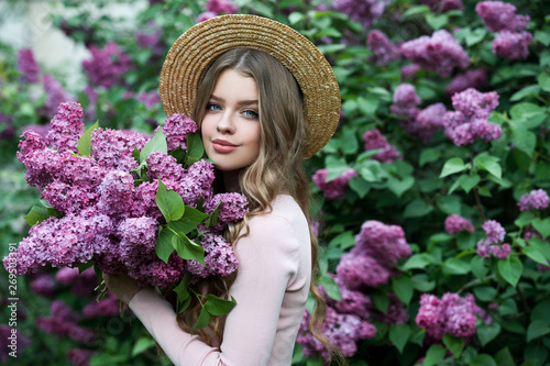Beautiful girl in lilac Garden. Girl with lilac flowers in springtime. Gardening. © darkfreya