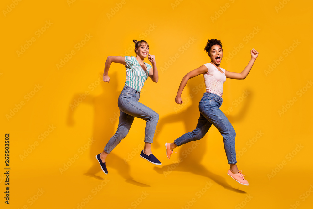 Full length body size view photo positive cheerful carefree student free time weekend summer energy race content excited childish curly haircut stylish trendy jeans clothing isolated yellow background