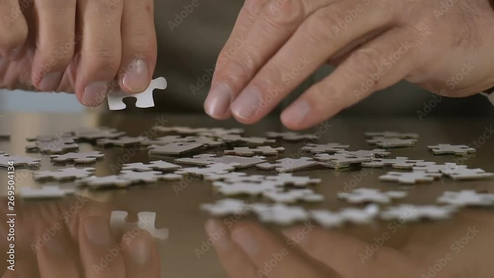 Aged man trying to combine puzzle, rehabilitation, thought process support Aged man trying to combine puzzle, rehabilitation, thought process support