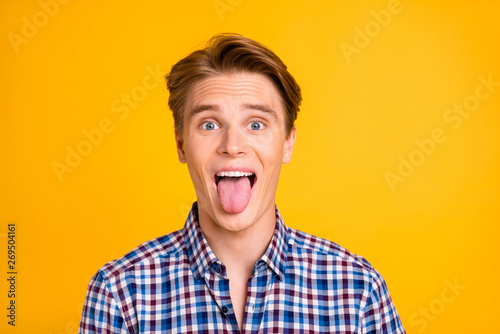 Obraz na plátně Handsome guy showing tongue isolated bright background