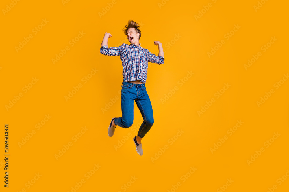 Full length body size view portrait of his he nice attractive cheerful cheery optimistic guy in checked shirt having fun flying isolated over bright vivid shine yellow background