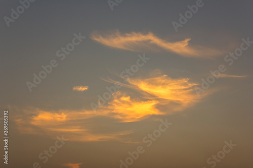 bright orange clouds in a gray blue evening sky © Pavel