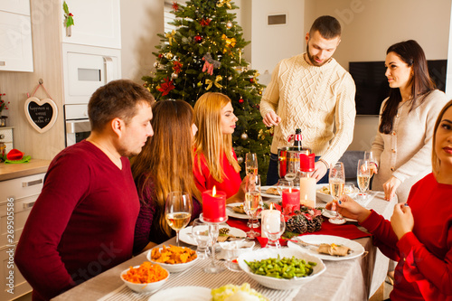 Group of people celebrating New year around table