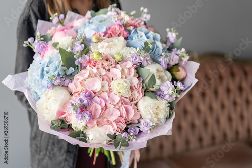 Fototapeta Naklejka Na Ścianę i Meble -  Large Beautiful bouquet of mixed flowers in woman hand. Floral shop concept . Beautiful fresh cut bouquet. Flowers delivery
