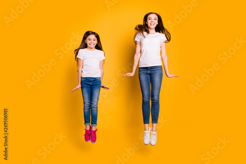 Full length body size photo beautiful her she different age diversity ladies weekend spend free time jump high carefree having fun wear casual white t-shirts jeans denim isolated yellow background