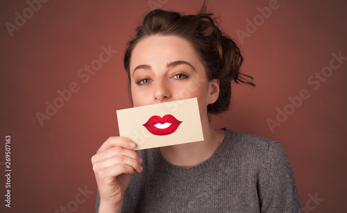 Person smiling with a card on the front of his mouth with a red lips on it 