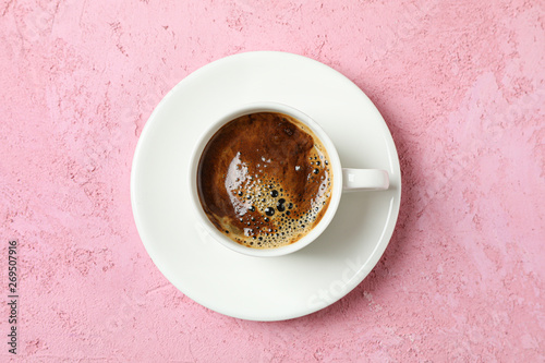 Cup of coffee with frothy foam on color background, space for text and top view. Coffee time accessories