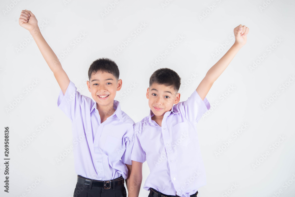 Little Asian sibling boys in student uniform pose together on white background Little Asian sibling boys in student uniform pose together on white background