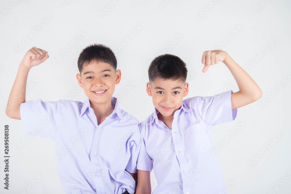 Little Asian sibling boys in student uniform pose together on white background Little Asian sibling boys in student uniform pose together on white background