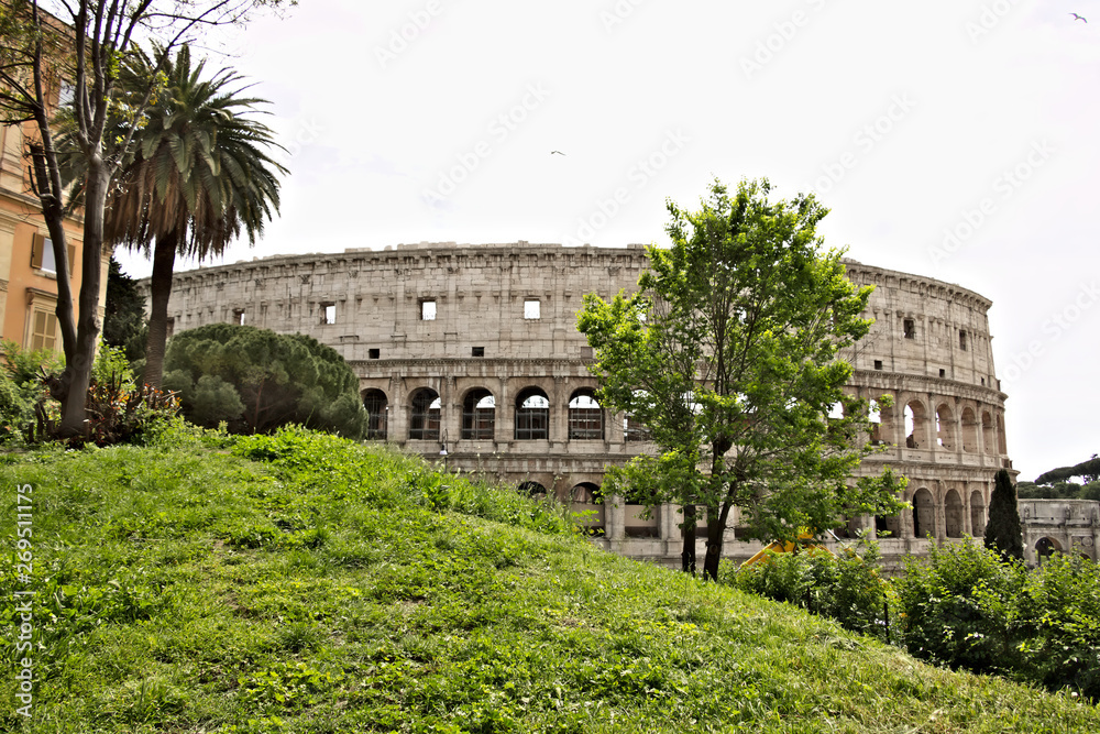The colosseum with a green lawn on the hill of Colle Oppio.