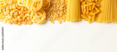 Obraz  z motywem Different pasta on white background, space for text. Dry uncooked whole pasta