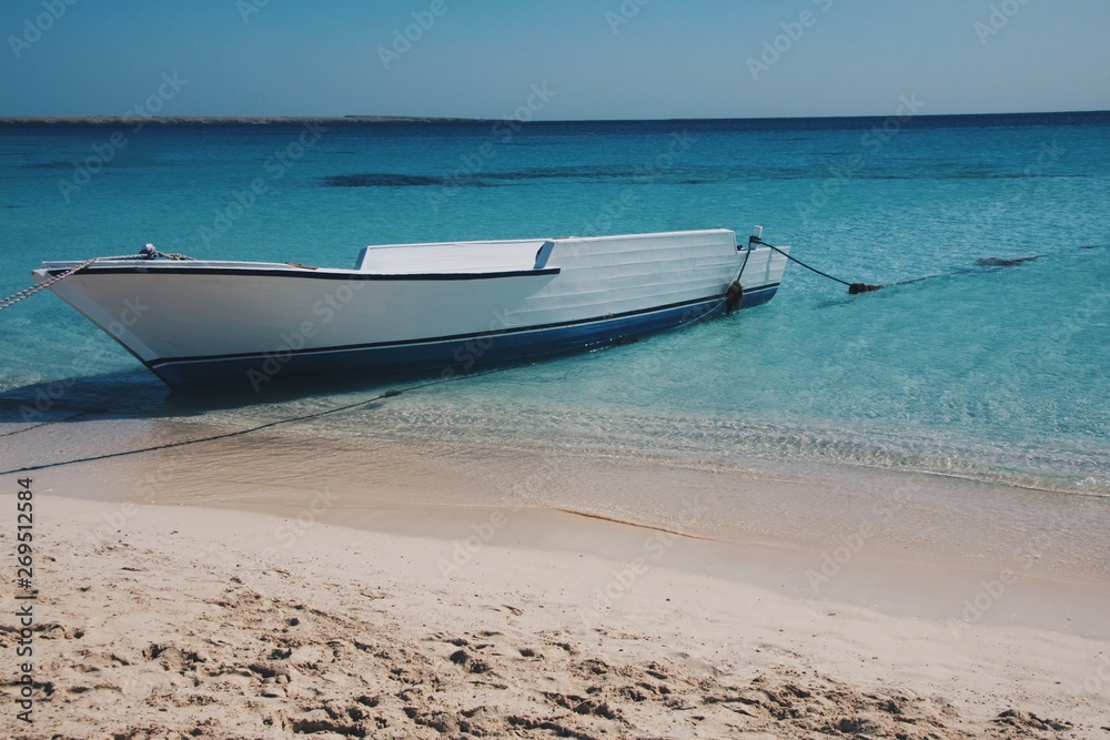 White boat in the clear blue ocean water White boat in the clear blue ocean water
