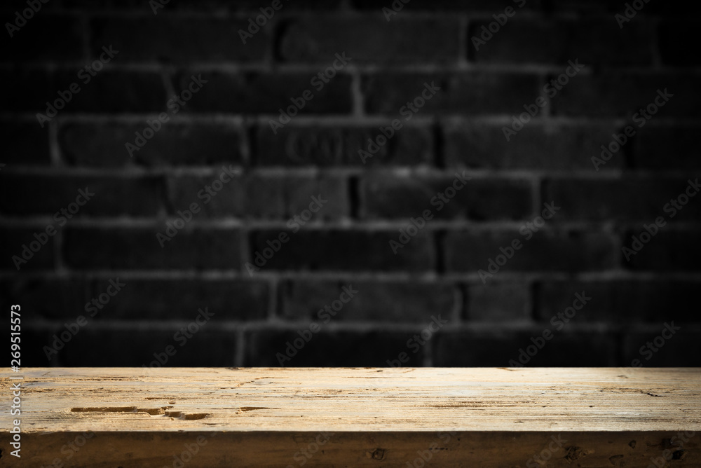 Old wooden table with brick background dark Old wooden table with brick background dark
