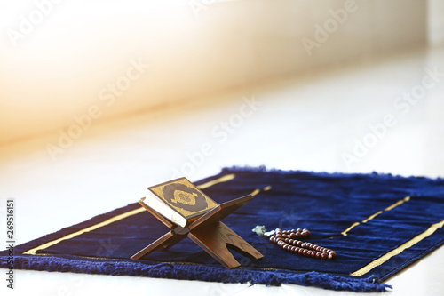 Koran and tasbih on Muslim prayer mat