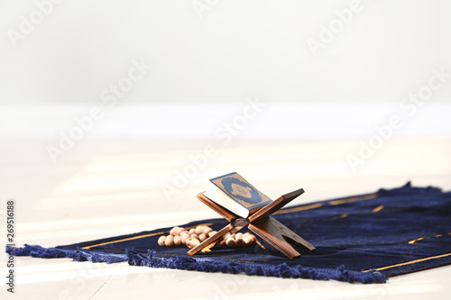 Koran and tasbih on Muslim prayer mat