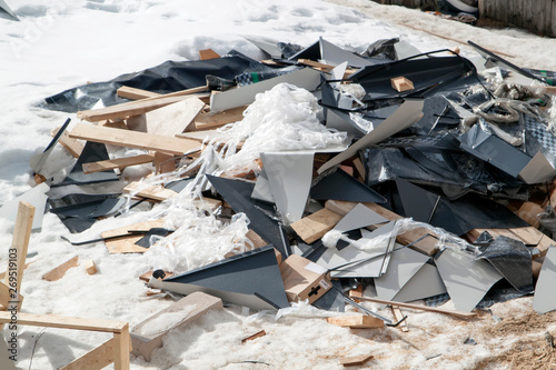 debris with roof scraps stored near house under construction in winter