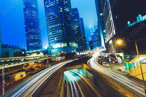 Street traffic at twilight sunset in Hong Kong. Office skyscraper buildings and with blurred car light trails. Hong Kong, Special administrative region in China. Toned