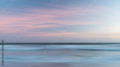 Beautiful artistic colorful landscape image of blurred waves at sunset in Devon Enlgand © veneratio