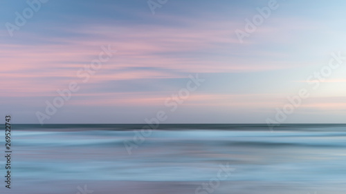 Beautiful artistic colorful landscape image of blurred waves at sunset in Devon Enlgand