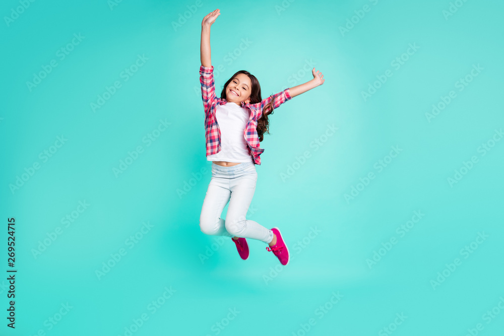 Full length body size view photo of lovely nice pretty little girl raise hands move  movement enjoy free time weekend dressed checked modern shirt stylish sneakers trousers isolated green background