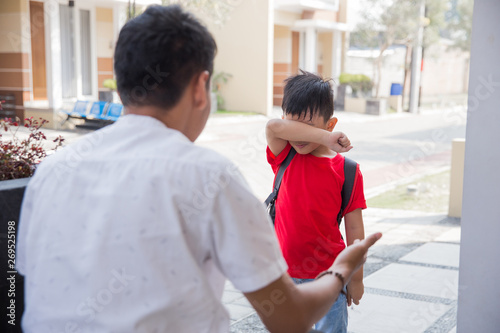 Angry father scolding son in front of the house