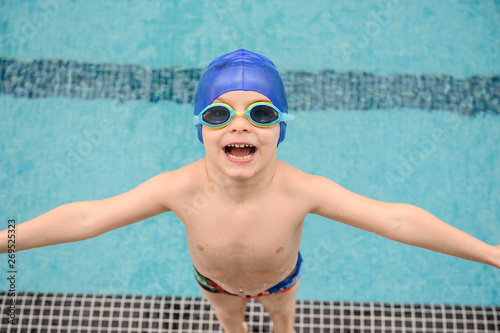 close up photo of 7-year boy preparing to jump in the swiimming pool photo