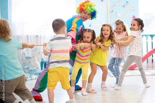 Excited kids and clown play...
