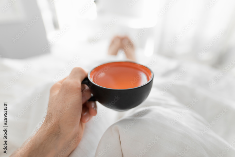 1st person view, man drinking morning tea in a bed