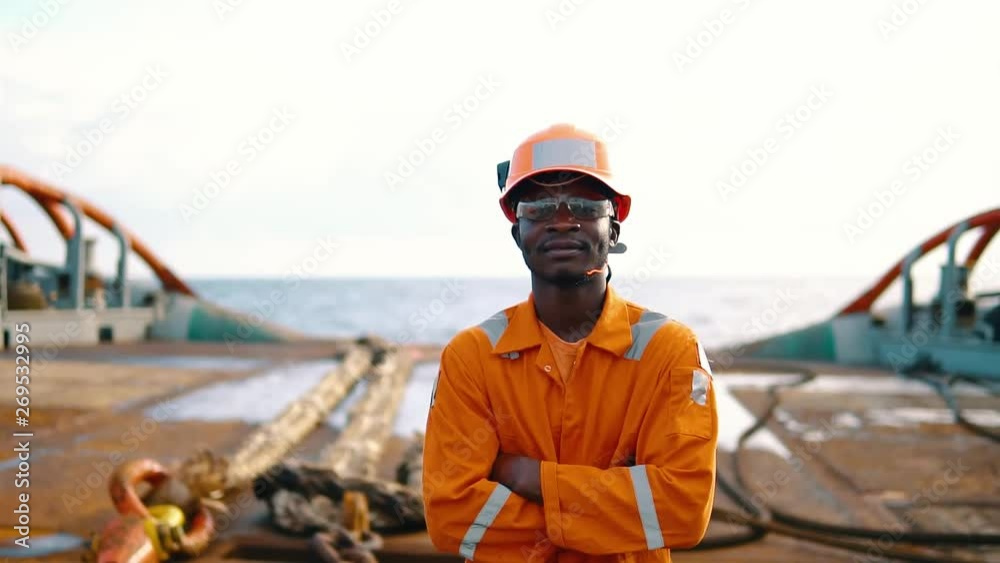 Tired Seaman AB or Bosun on deck of vessel or ship , wearing PPE