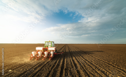  Farmer with tractor seeding soy crops at agricultural field