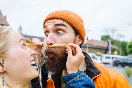 Young beautiful loving couple, a blonde woman together with her beautiful bearded man, crazy emotions, hipsters. Fun and creative, outdoor portrait, close up photo