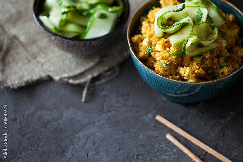 Traditional Burmese fried rice with shallots,turmeric and fresh cucumber strips mixed with chopped green onions and vinegar has been stir-fried in a wok and perfect for vegan. copy space,top view
