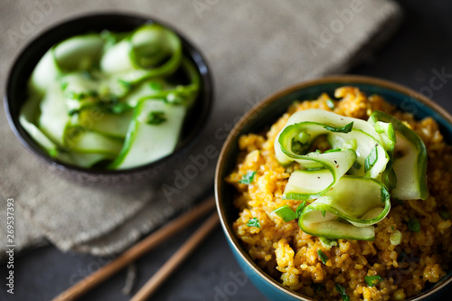 Traditional Burmese fried rice with shallots, turmeric and fresh cucumber strips mixed with chopped green onions and vinegar has been stir-fried in a wok and perfect for vegan. close-up,top view