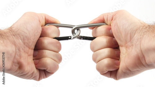 two clasped hands holding a climbing carabiners