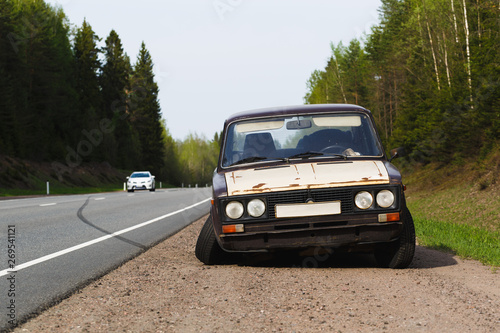 Car accident on the asphalt road. On the old car fell off the wheel. The object is in focus. The background is blurred