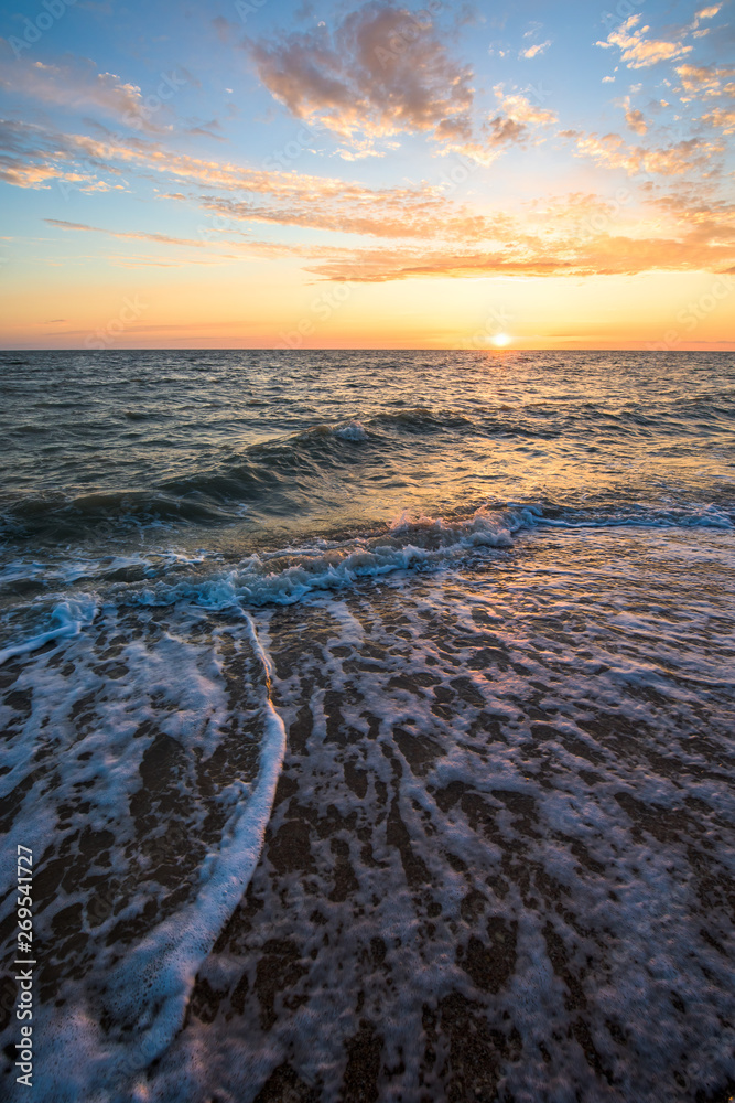 Fototapeta premium gorgeous sunset on the sea coast. photo on long exposure, waves at sea at sunset. pink sunset