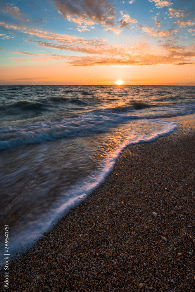 photo taken at long exposure, waves at sea at sunset