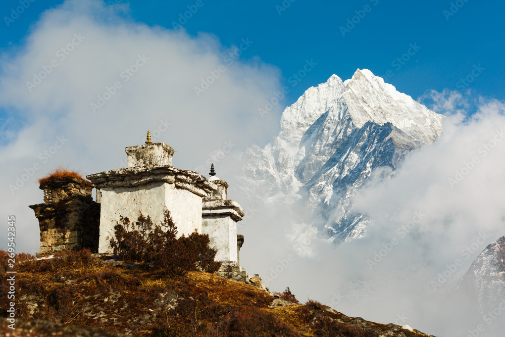 Everest trekking. In the frame stupa on the hill. The background is mountain covered by clouds. Nepal