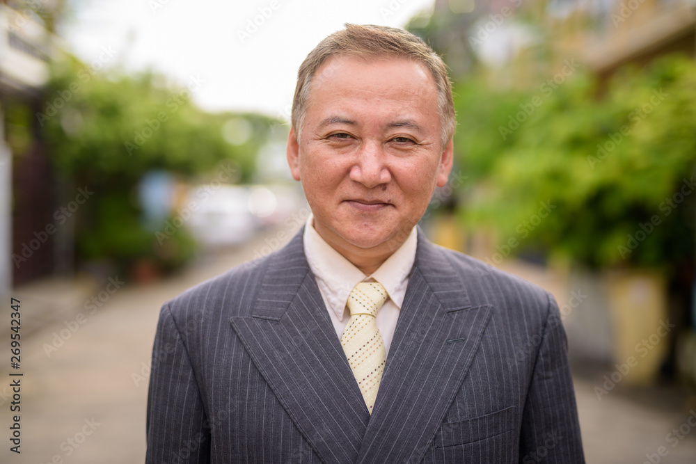 Mature Asian businessman in the streets outdoors Mature Asian businessman in the streets outdoors